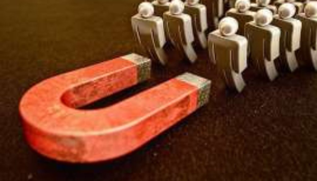 Red magnet attracts figures of people on a black background