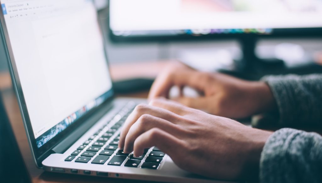 Man working at laptop; image by Glenn Carstens-Peters, via Unsplash.com.